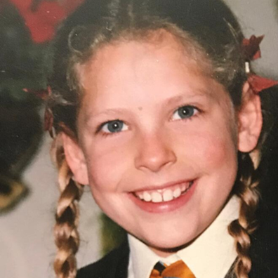 Anna Balcombe as a young girl with plaited hair in school uniform